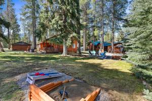 a cabin in the woods with a fire pit in the yard at Glacier Cabins in Martin City