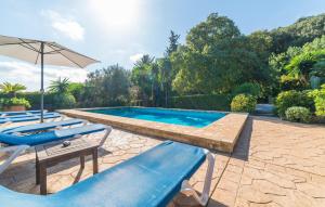a swimming pool with lounge chairs and an umbrella at Ca Les Estamenyes in Pollença