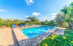 a swimming pool in a yard with chairs and trees at Ca Les Estamenyes in Pollença