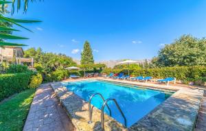 a swimming pool with chairs and umbrellas in a yard at Ca Les Estamenyes in Pollença