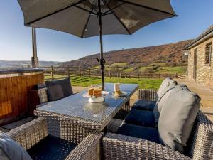 a table and chairs with an umbrella on a patio at 3 Bed in Crickhowell oc-90757 in Cwm-du