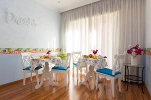 a white dining room with a table and chairs at Malkavacanze B&B in Rome