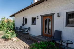 a white house with a wooden door and a table and chairs at 100 m2 Familien 4-Zimmer Apartment mit Terrasse und Burgblick und gratis parken in Maria Enzersdorf