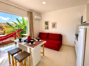 a living room with a red couch and a table at Flats Morro de São Paulo in Morro de São Paulo