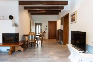 a living room with a dining room table and a television at 100 m2 Familien 4-Zimmer Apartment mit Terrasse und Burgblick und gratis parken in Maria Enzersdorf