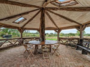 a large wooden tent with a table and benches at 2 Bed in Lutterworth oc-93762 in Boughton