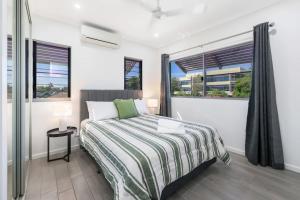 a bedroom with a bed and two windows at Perfect in Parap in Paraparap +14 photos