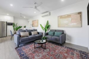 a living room with two couches and a table at Perfect in Parap in Paraparap