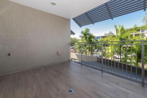 an empty room with a balcony with palm trees at Perfect in Parap in Paraparap