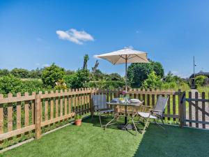 a table and chairs with an umbrella on a fence at 1 Bed in Hawarden oc-93595 in Hawarden +16 photos