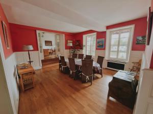 a dining room with red walls and a table and chairs at Gîte De Charme - La Mésangerie in Saint-Satur