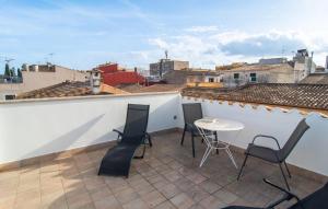 a balcony with chairs and a table on a roof at Petit Arta - Sa Botigueta in Artá