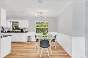 a white kitchen with a table and chairs at Blue Spring Getaway with Fire Pit in Orange City