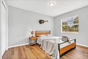 a white bedroom with a bed and a window at Blue Spring Getaway with Fire Pit in Orange City