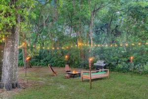a backyard with a barbecue and a grill with lights at Blue Spring Getaway with Fire Pit in Orange City