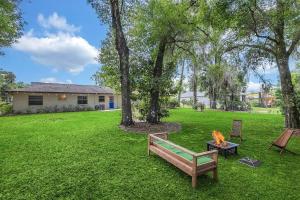 a park with a bench and a fire in the grass at Blue Spring Getaway with Fire Pit in Orange City