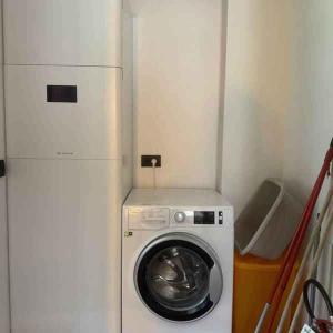 a refrigerator and a washing machine in a small room at Chalet in Pieve di Ledro-Ledrosee 57751 in Pieve Di Ledro