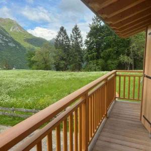 a wooden deck with a view of a green field at Chalet in Pieve di Ledro-Ledrosee 57751 in Pieve Di Ledro