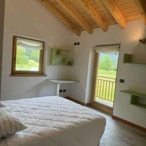 a bedroom with a bed and a large window at Chalet in Pieve di Ledro-Ledrosee 57751 in Pieve Di Ledro