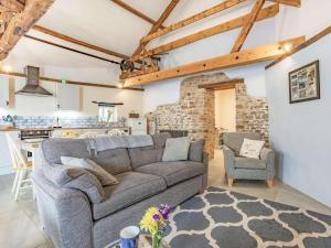 a living room with a gray couch and a kitchen at 2 Bed in Bideford oc-60765 in Buckland Brewer