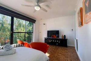 a bedroom with a bed and chairs and a television at The Newton in Lyons
