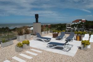 a group of chairs sitting on a patio with the ocean at Almarena Apart & Hotel Boutique in Costa del Este