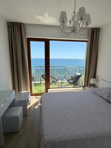 a bedroom with a large window with a view of the ocean at Kabakum See infinity in Varna City