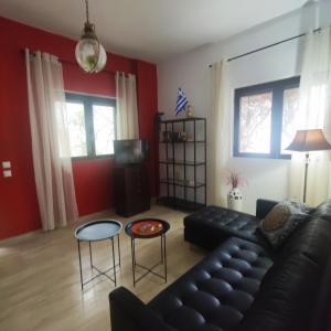a living room with a black leather couch and a table at Cozy City Apartment - sleeps 2 in Rhodes Town