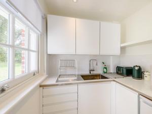 a white kitchen with white cabinets and a sink at 1 Bed in Manningtree oc-78389 in Lawford