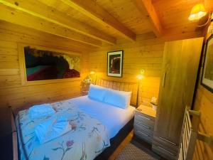 a bedroom with a bed in a wooden cabin at Garden Cabin at Shengan in Banavie