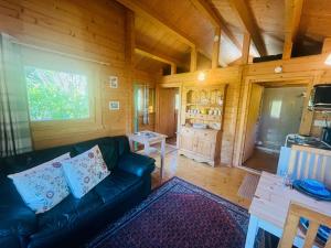 a living room with a couch in a wooden cabin at Garden Cabin at Shengan in Banavie