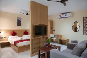 a hotel room with a bed and a flat screen tv at Lumis studio apartment in Hyderabad