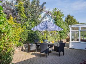 a patio with a table and chairs and an umbrella at 3 Bed in Conwy oc-95906 in Conwy