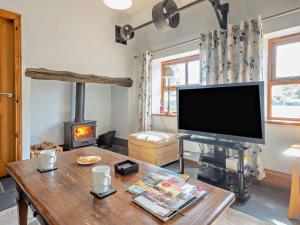a living room with a tv and a wood stove at 3 Bed in Conwy oc-95906 in Conwy