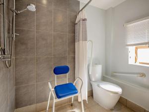 a bathroom with a toilet and a blue chair at 3 Bed in Conwy oc-95906 in Conwy +22 photos