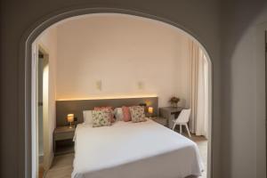 a bedroom with a large white bed with pillows at Antonios Hostal in Sitges