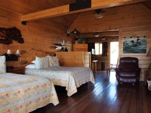 a bedroom with two beds in a log cabin at Alaskan Suites in Homer
