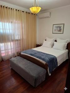 a bedroom with a large bed and a window at Constança House in Corroios