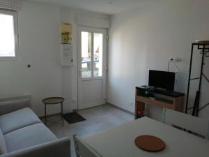 a living room with a couch and a chair and a table at L'escale in Mers-les-Bains