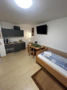 a room with a bed and a kitchen with a table at Babsi Appartments - leben am Land in Wels