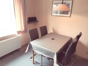 a dining room table with chairs and a table and a lamp at Steenshof in Heringsdorf
