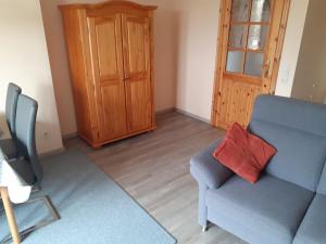 a living room with a blue couch and a red pillow at Steenshof in Heringsdorf
