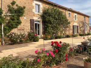 a brick house with flowers in front of it at La Grange aux coccinelles in Saint-Martin-des-Fontaines