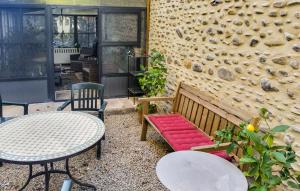 a patio with a bench and tables and a wall at Awesome Home In Charritte-De-Bas With Wifi in Charritte-de-Bas +11 photos