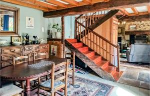 a dining room with a table and a staircase at Awesome Home In Charritte-De-Bas With Wifi in Charritte-de-Bas