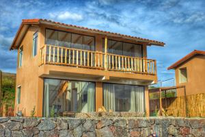 a house with a balcony on top of a stone wall at Mirador el Prado in Cheqquerec