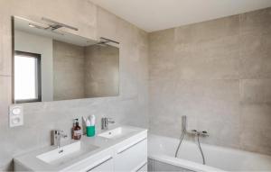 a bathroom with two sinks and a mirror and a tub at Villa Botero Dinard in Dinard