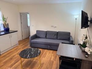 a living room with a couch and a table at Chiltern Nursuries in Amersham