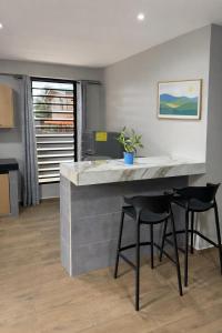 a kitchen with a large counter with two stools at Southgate Residence in Paramaribo