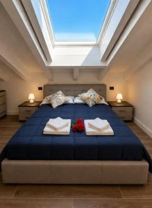a bedroom with a large blue bed with a skylight at Apt. Aries - Penthouse Menaggio in Menaggio +26 photos